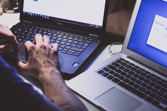Two laptops being typed on