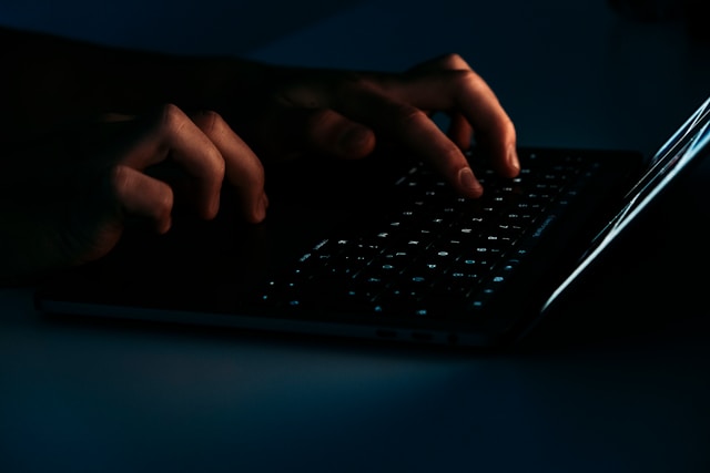 hands on a keyboard in the dark