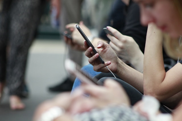people on their phones sitting down